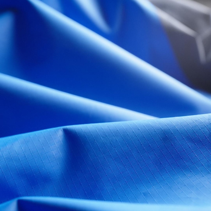 Plan très rapproché d'un tissus synthétique bleu, détails d'un textile imperméable.