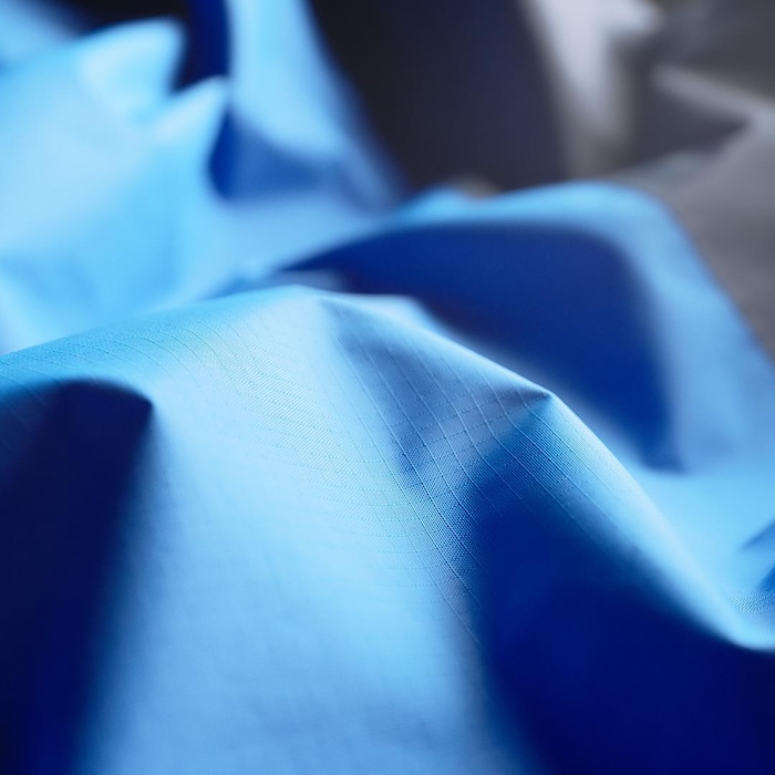 Plan très rapproché d'un tissus synthétique bleu, détails d'un textile imperméable.