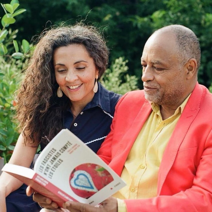 Une femme et un homme regardent un livre. 
