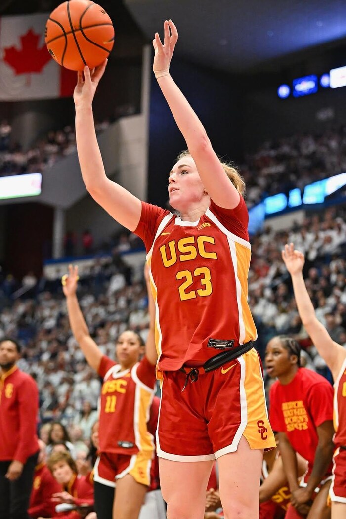 Une basketteuse tente un tir à trois points.