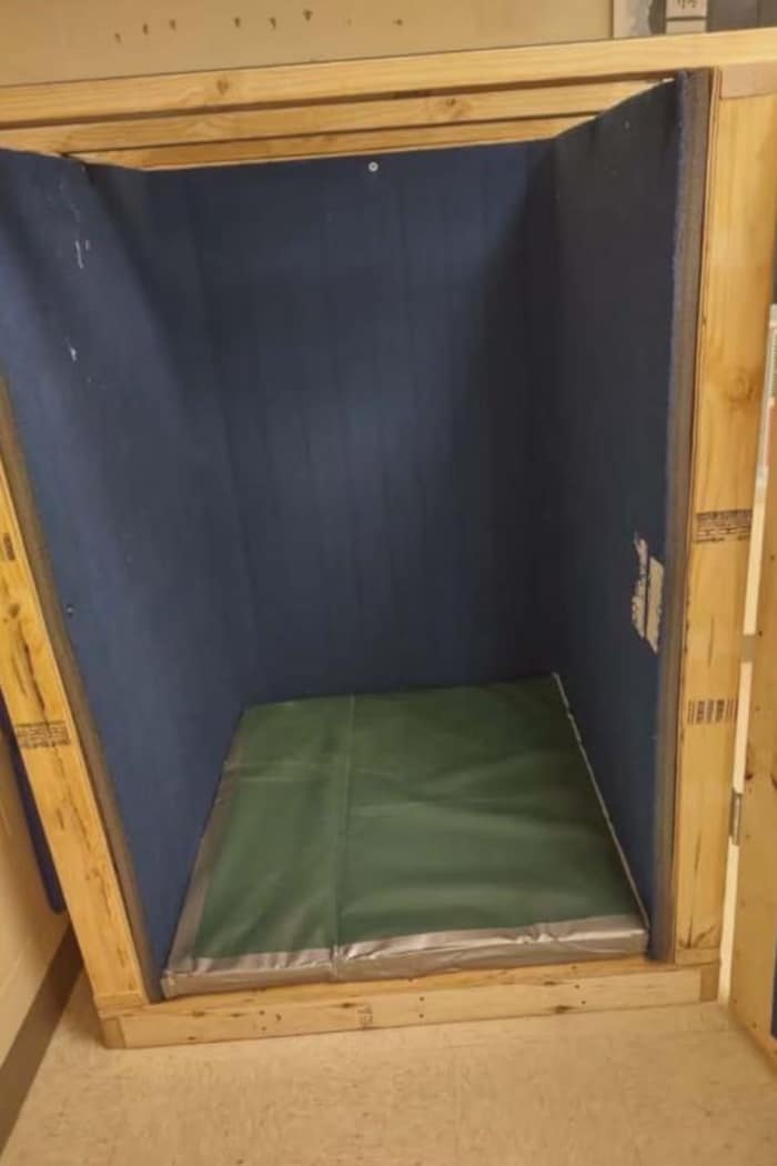 Une boîte en bois avec un petit matelas.