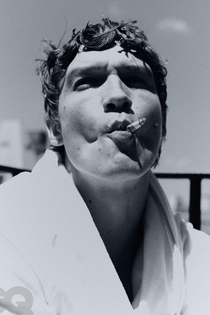 Photo en noir et blanc d'un homme qui fume. 