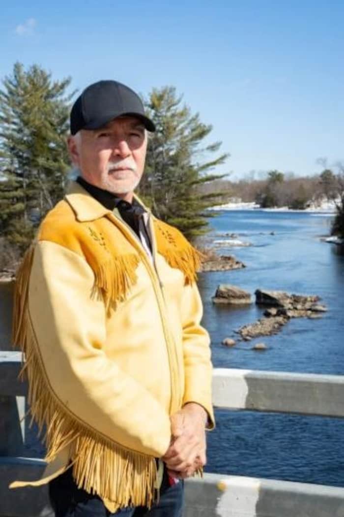 Un homme avec en arrière-plan un cours d'eau et la forêt.
