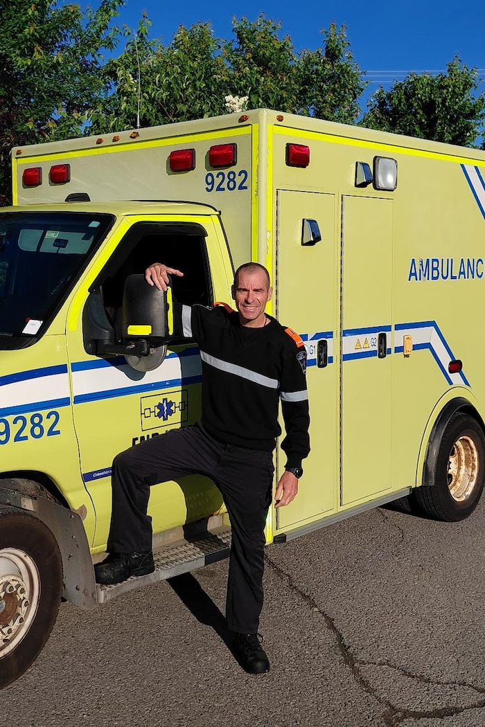 Il prend la pose devant une ambulance.