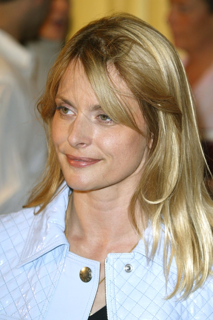 Une femme blonde sourit.