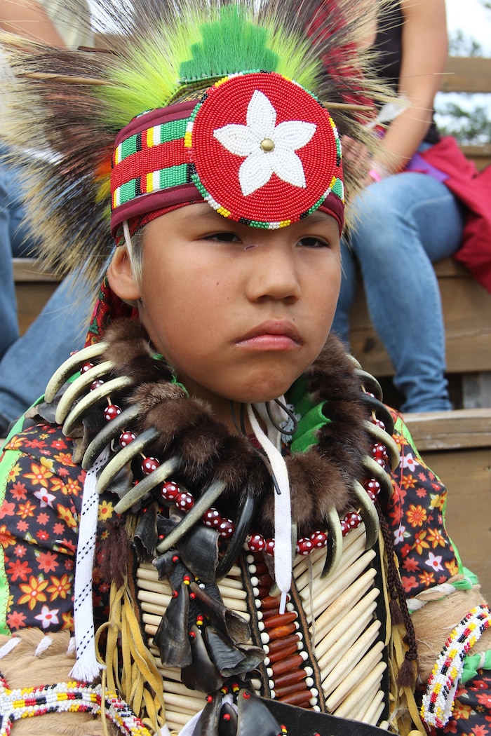 Un jeune Autochtone est habillé dans un costume traditionnel.