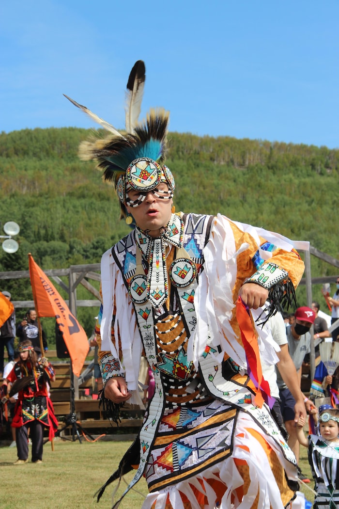 Une personne porte une regalia blanche lors du pow-wow de Wemotaci.