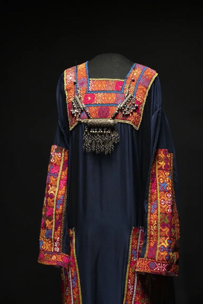 Une robe noire ample ornée de tatriz multicolore.