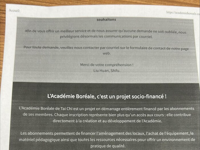 Une publicité de l'Académie Boréale, un projet « socio-financé » dont un message est signé par Liu Huan, imprimée et posée sur une table.
