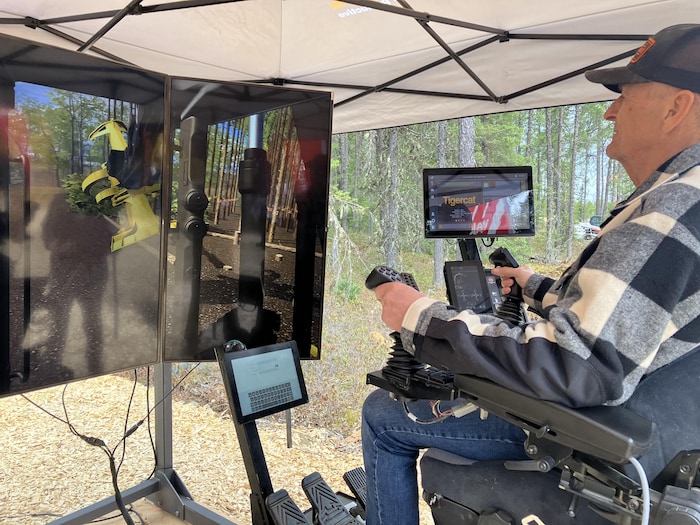 Un homme aux commandes d'une machine sur un simulateur dans un kiosque.