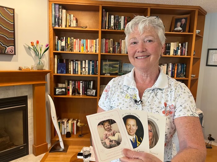 A woman holds funeral cards.