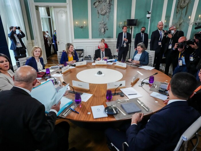 Les ministres des Affaires étrangères du G7, assis et discutant autour d'une table. 