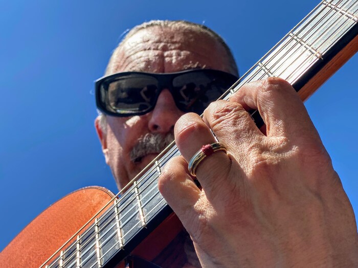 Le musicien André Thibault avec sa guitare.