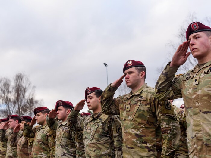 Des soldats font le salut en uniforme.