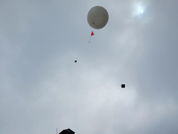 Un gros ballon blanc est envoyé dans le ciel juste au-dessus de la tour d'observation de Preissac.