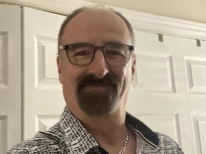 L'homme porte une barbe et des lunettes. Il se photographie en égoportrait.