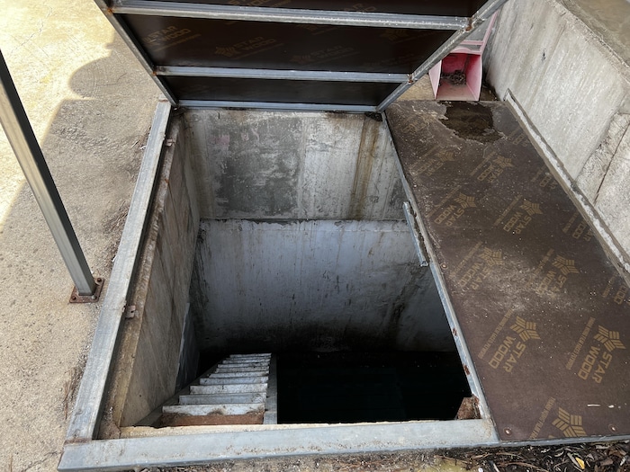 A door overlooks a bunker dug in the ground.