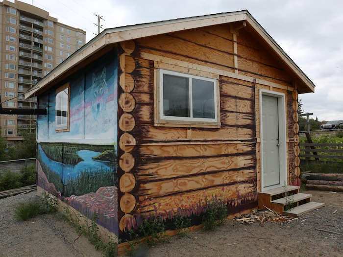 Une cabane ornée d’un paysage peint sur l’un de ses murs extérieurs.