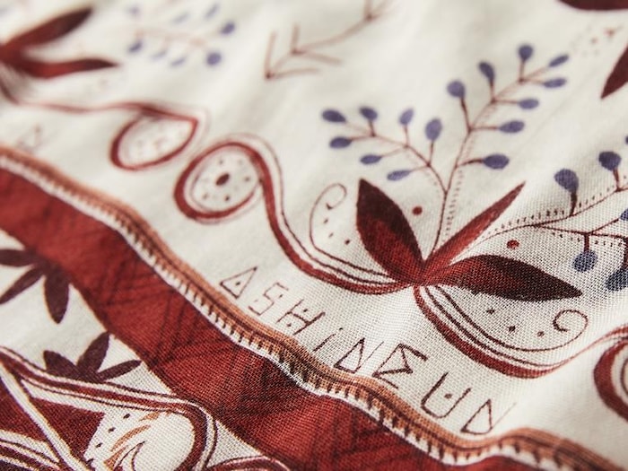 Un foulard avec un gros plan sur les motifs qui y figurent.