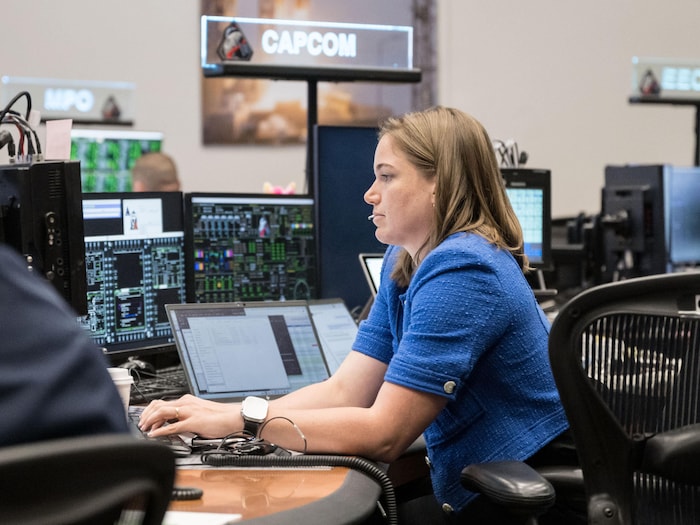 Jenni Gibbon assise à un poste de travail avec de multiples écrans.