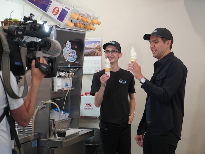 Charles Milliard et un employé de crèmerie se tiennent l'un à côté de l'autre avec leur cornet respectif.