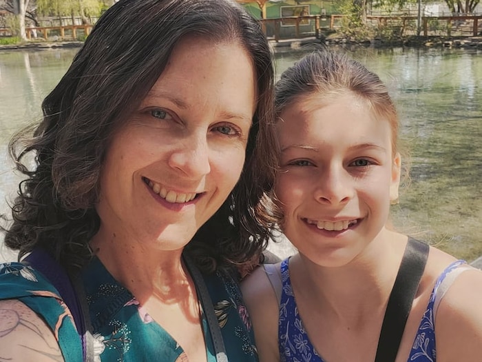Une dame et sa fille près d'un cours d'eau.