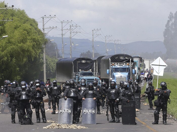 Des policiers face à un barrage de camions.