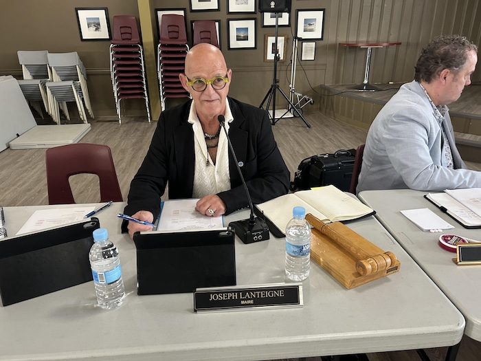 Un homme assis derrière une table.