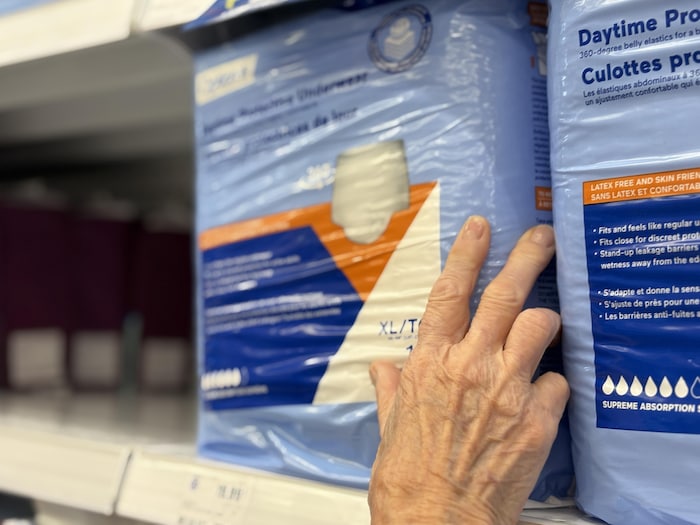 Une main sur un paquet de culottes d'incontinence.
