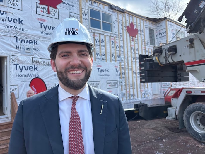 David Hickey, coiffé d'un casque de construction, pose pour la photo sur un chantier.