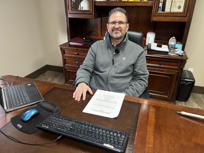 Denis Losier assis à son bureau.