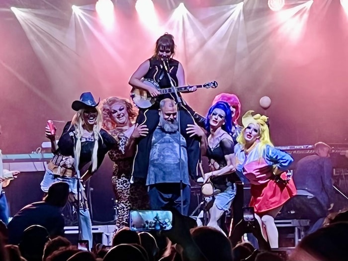 Les drag queens sur scène, au spectacle du 15 août à Acadie Rock à Moncton, entourent le chanteur des Hôtesses d'Hilaire Serge Brideau (au centre) et Lisa LeBlanc (sur ses épaules).