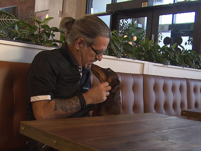 L'éducateur canin Jean Lessard avec un chien saucisse.
