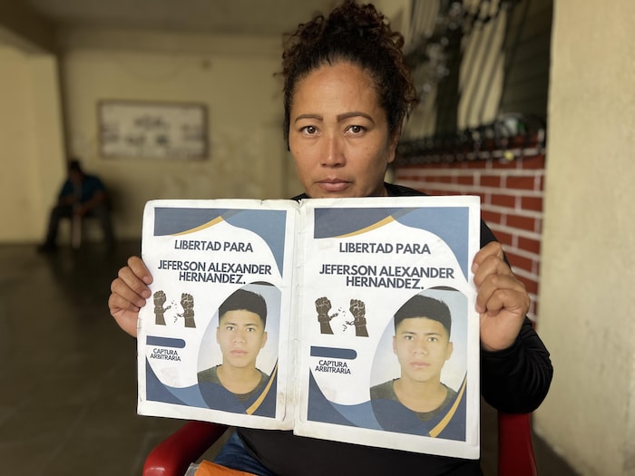 La femme tient deux affiches réclamant la liberté pour son garçon.
