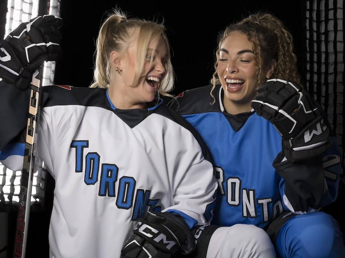 Emma Maltais et Sarah Nurse rient en présentant les chandails de l'équipe de Toronto.