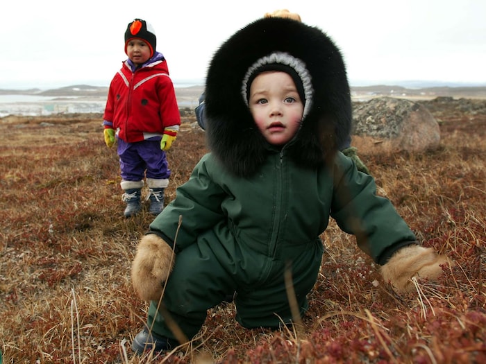 Deux enfants dans un champ, à Iqaluit.