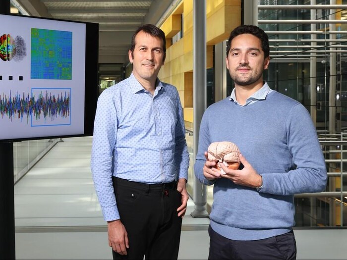 Les chercheurs Dimitri Van De Ville et Enrico Amico dans un corridor du Laboratoire de traitement d’images médicales de l’EPFL.