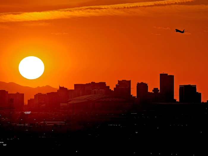 Avião decolando em um pôr do sol ardente.