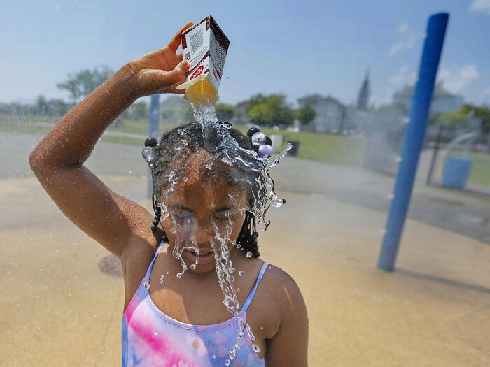 Little girl pouring water on her head.