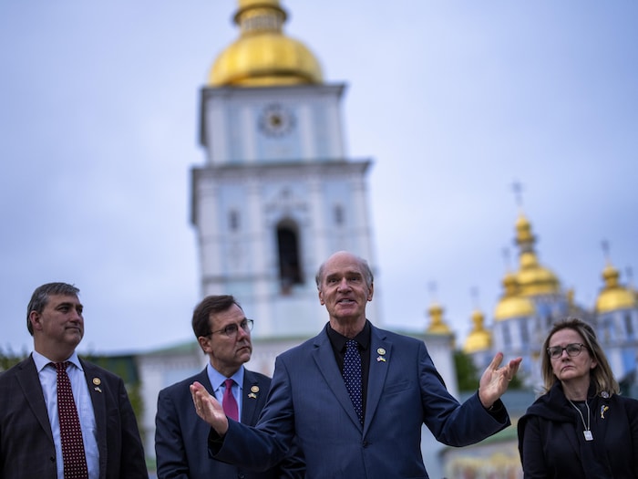 Trois hommes et une femme debout devant une cathédrale à Kiev.