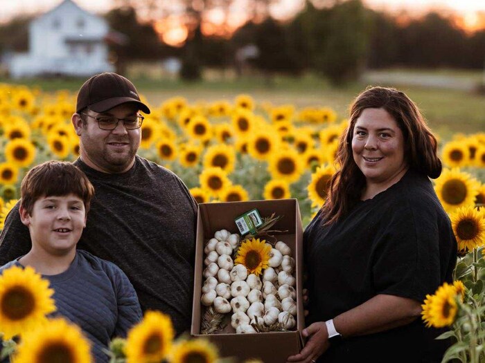 Jade Cazelais, Christian Leclerc et Léo Cazelais-Leclerc dans leur champ de tournesols.
