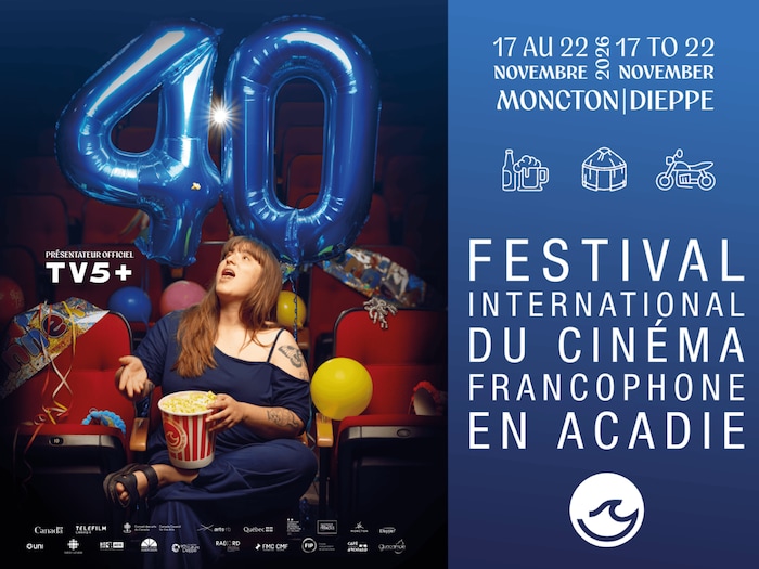 Caroline Savoie, dans une salle de cinéma, lance du popcorn. Derrière elle, des ballons bleus forment le chiffre 40. 