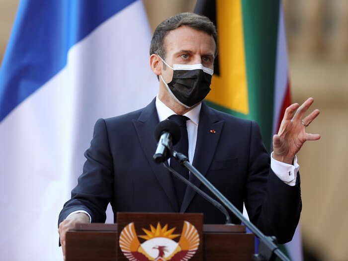  Le président Macron derrière un lutrin et masqué.