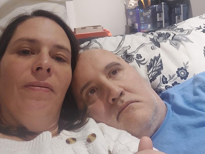 Geneviève Coutu et Louis sont étendus côte à côte dans un lit.