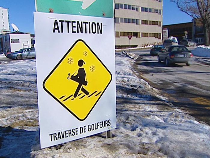 Une affiche au centre-ville de Rimouski qui indique Attention : traverse de golfeurs.