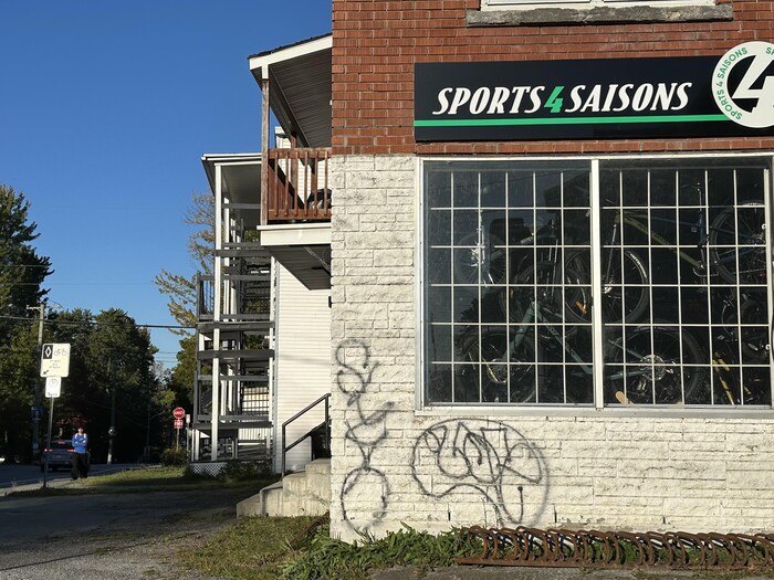 Un graffiti sur le mur du commerce Sports 4 saisons. 