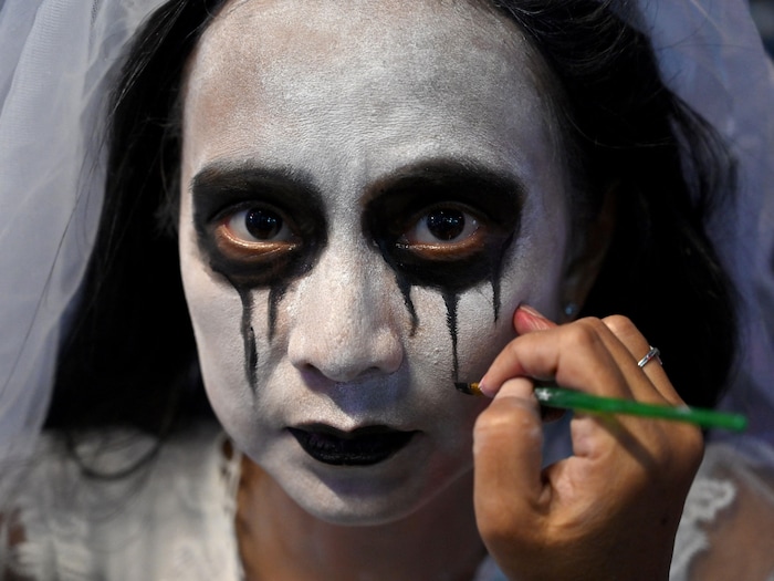 Une femme maquillée de noir et de blanc dans une photo prise le 31 octobre 2021.