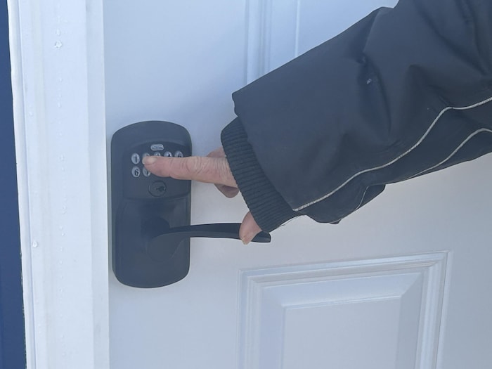 Une main tourne une poignée de porte.
