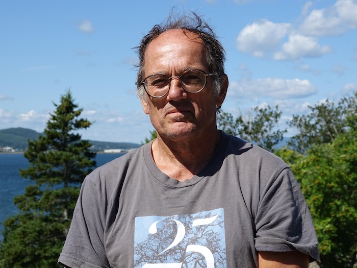 Jean-Marc Beaulieu photographié à Miguasha, avec le paysage de Dalhousie et la baie des Chaleurs derrière.