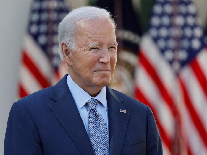 Uma foto de Joe Biden em frente às bandeiras dos EUA.